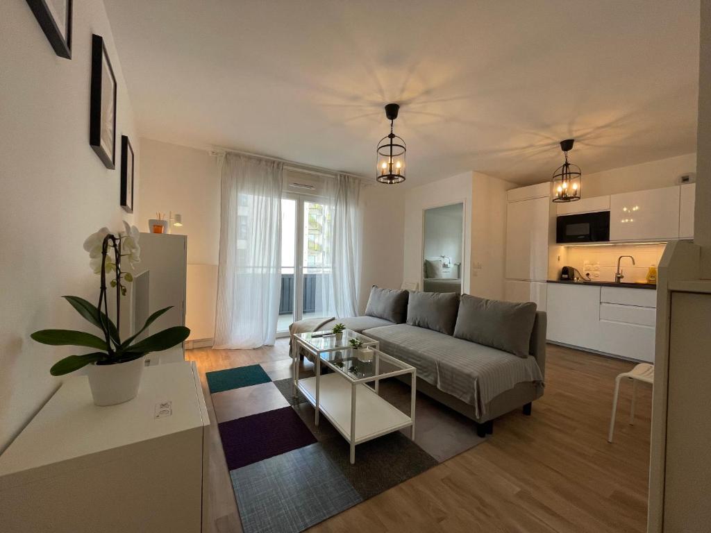 a living room with a couch and a table at Apartment near to Paris CDG in Aulnay-sous-Bois