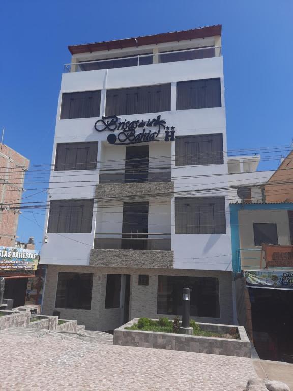 un edificio blanco alto con un letrero. en BRISAS DE LA BAHIA HOTEL, en Paracas