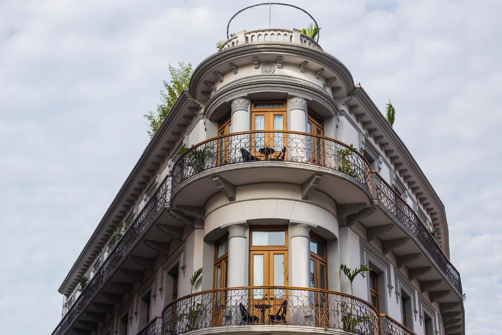 a tall white building with orange doors and balconies at La Concordia - Boutique Hotel in Panama City