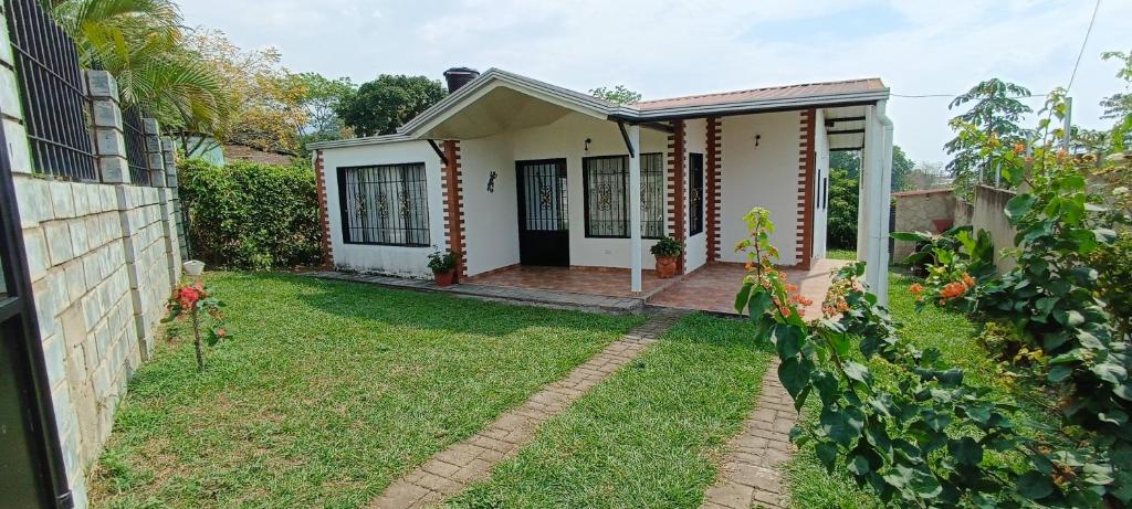 a small white house with a yard at Agradable casa de campo en La Ulloa, Rivera(Huila) in Rivera