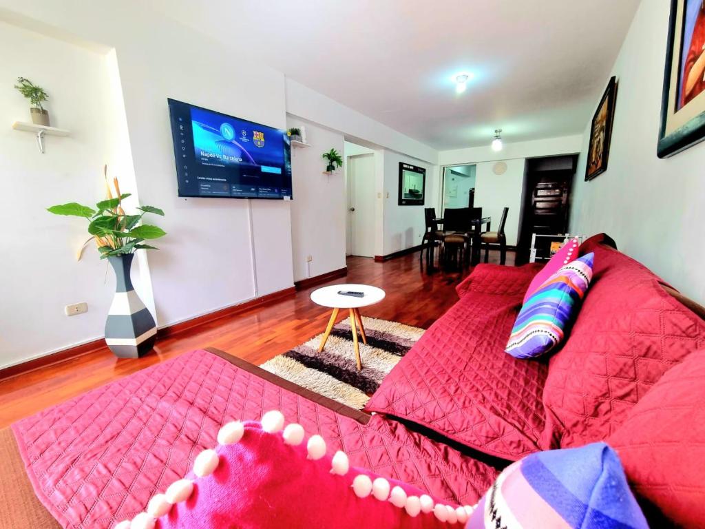 uma sala de estar com um sofá vermelho e uma televisão de ecrã plano em Lima Gold Apartaments Family 4B203 em Lima