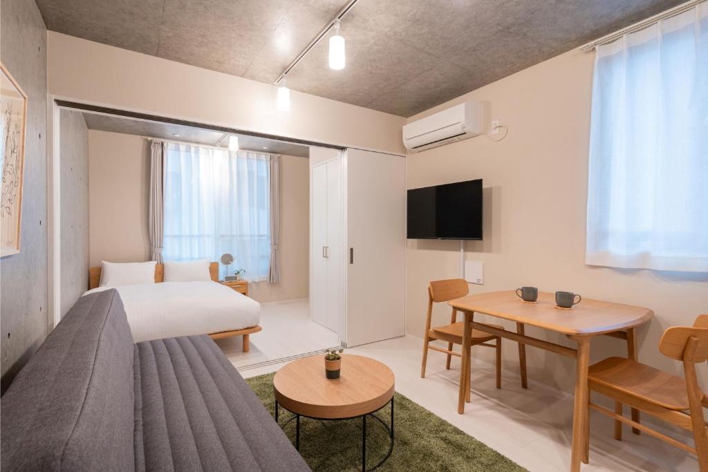 ein Hotelzimmer mit einem Bett und einem Tisch in der Unterkunft MINI HOUSE Tokyo South in Tokio