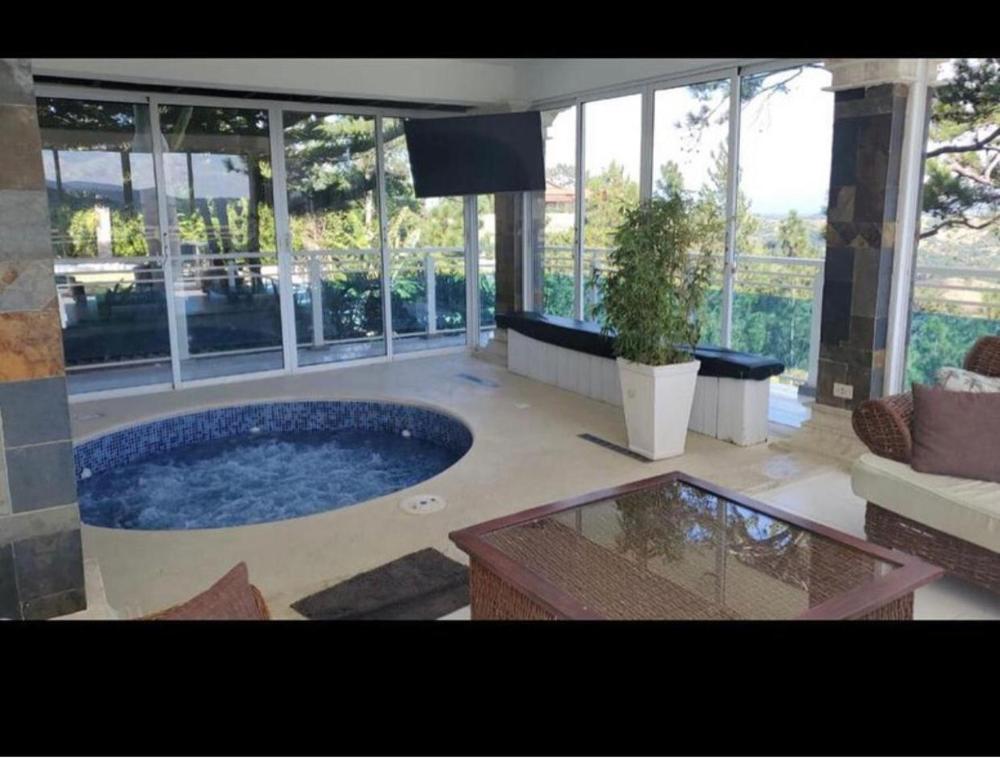 una gran piscina en una habitación con ventanas en villa Doña rosa, en Concepción de La Vega