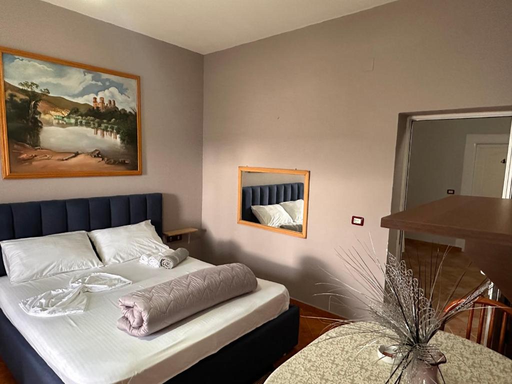 1 dormitorio con 1 cama y una pintura en la pared en Hotel Belind en Berat