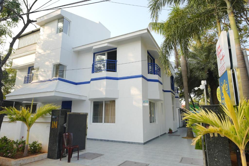 una casa blanca con acentos azules en Bay Breeze Suites, en Chennai