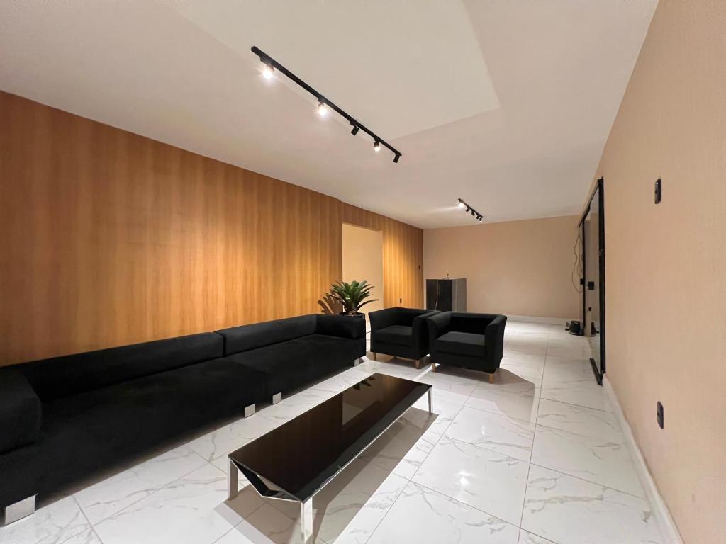 uma sala de estar com um sofá preto e uma mesa em VILA LITORANEA a em São Luís
