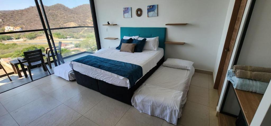 um quarto com uma cama e uma grande janela em Santa Marta- Pozos Colorados Ocean view Suite Bello Horizonte em Santa Marta