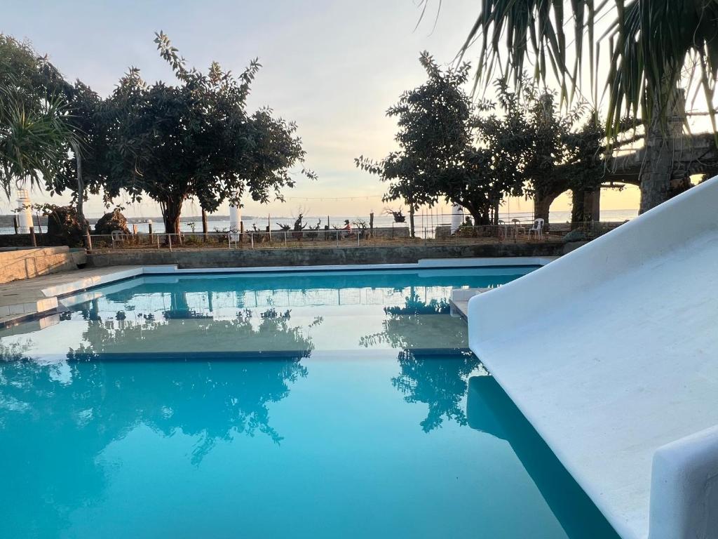 una gran piscina con agua azul y árboles en Kadilian Beach House, en Currimao
