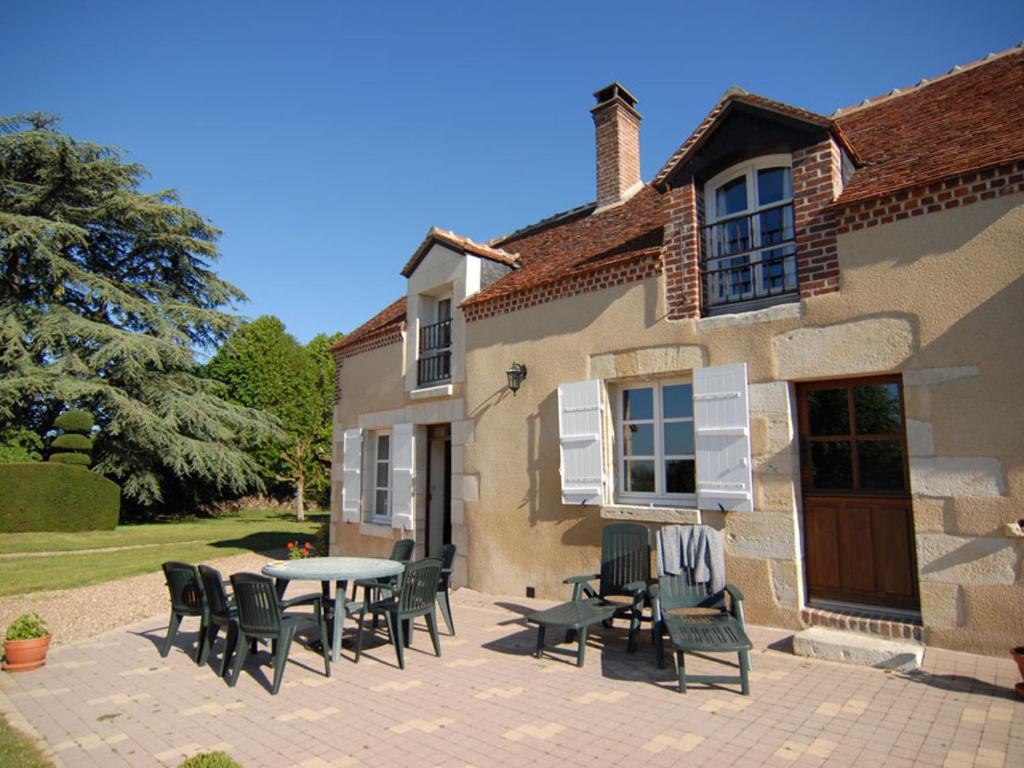 a patio with chairs and a table in front of a building at Maison de caractère avec jardin, climatisation et vélos près d'Amboise - FR-1-381-357 in Cangey