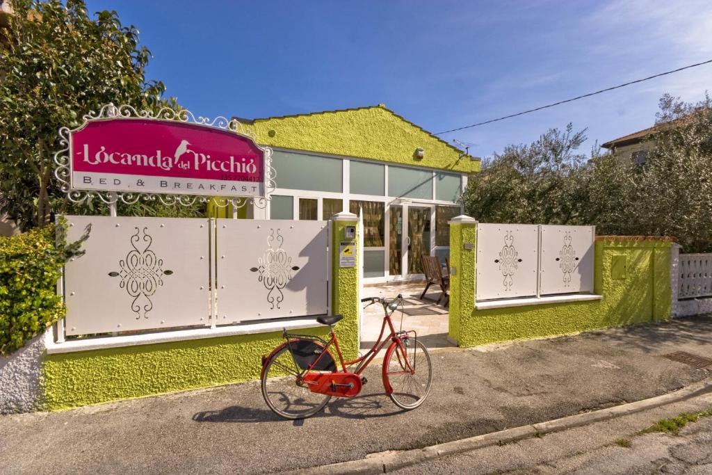 uma bicicleta vermelha estacionada em frente a um edifício em Locanda Del Picchio em Loreto