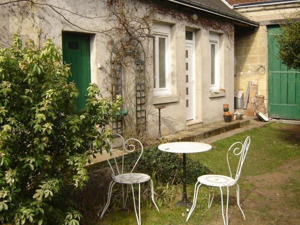 two tables and chairs in the yard of a house at Gîte Montlouis-sur-Loire, 3 pièces, 4 personnes - FR-1-381-436 in Montlouis-sur-Loire