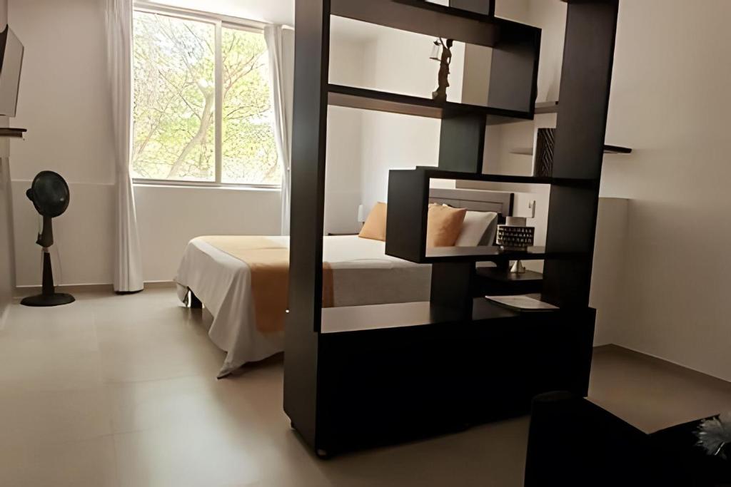 um quarto com uma cama e um espelho em 304 Moderno Aparta-Suite en Versalles Tipo Loft - Cali Tower Suites & Lofts em Cali