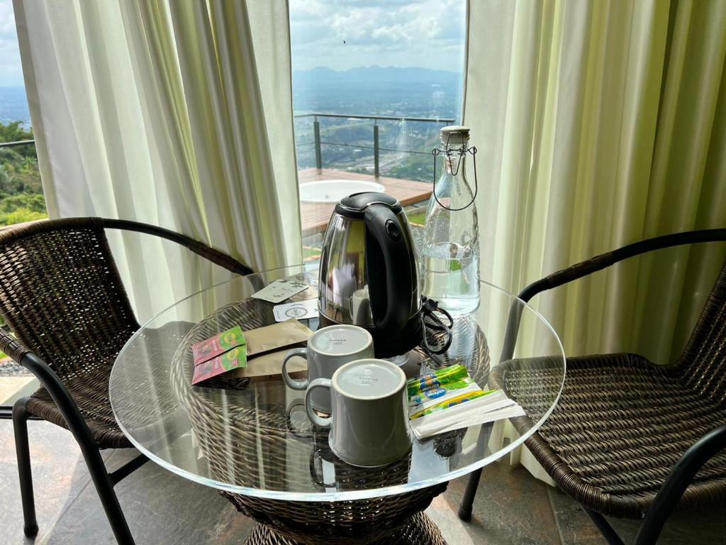 a glass table with a tea kettle and cups on it at Glamping ríos voladores pereira in Pereira