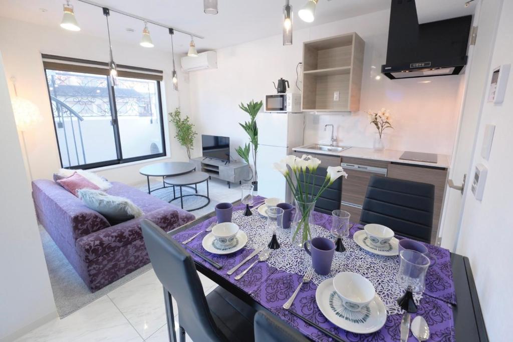 a kitchen and living room with a table with purple table cloth at HJ PLACE TAKANAWA in Tokyo