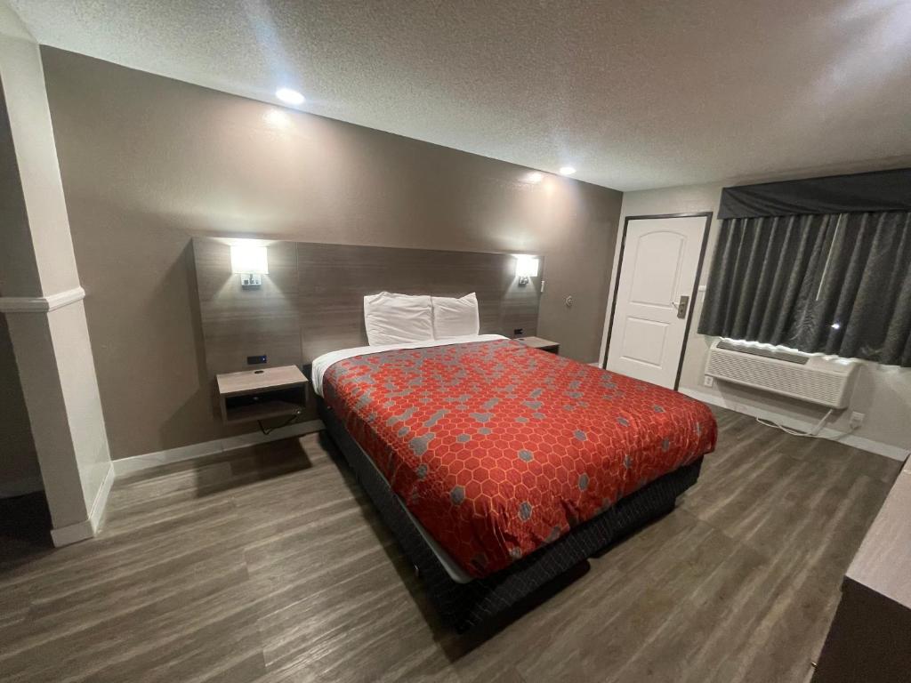 a hotel room with a bed and two night stands at Economy Inn in San Bernardino