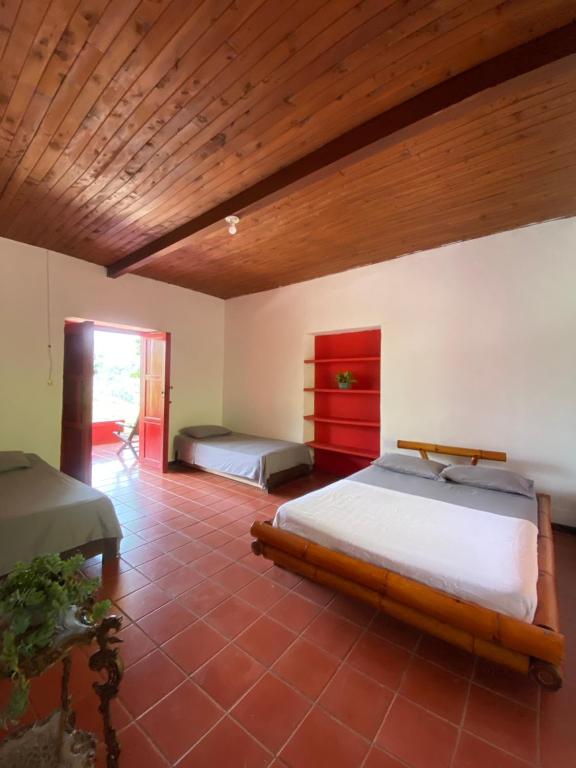una camera con 2 letti e un soffitto in legno di Hacienda la Chocha a San Rafael