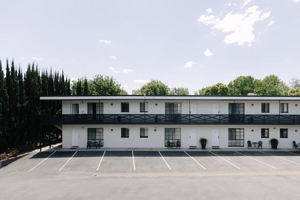 a large white building with a parking lot at Centralpoint Motel in Wagga Wagga