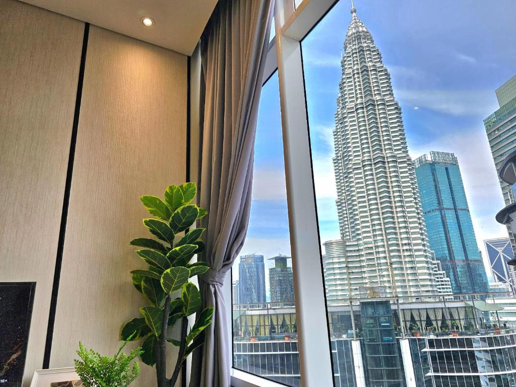 een kamer met een raam met uitzicht op een wolkenkrabber bij Sky Suites KLCC Kuala Lumpur in Kuala Lumpur