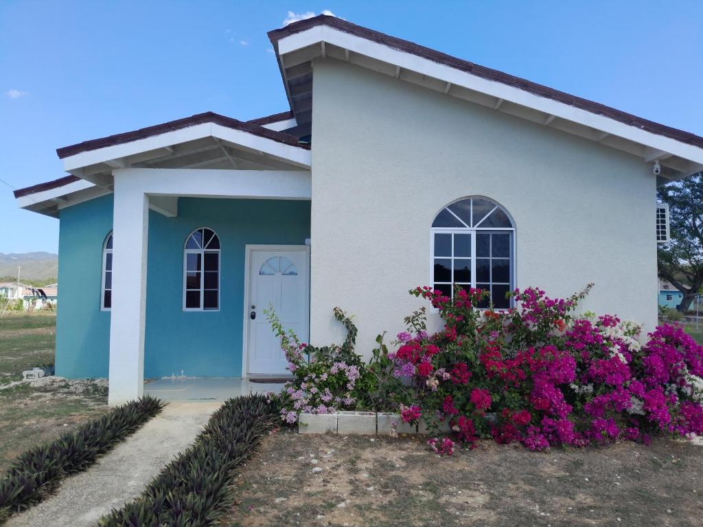 a small house with flowers in front of it at Loodik Vacation Home Brompton Manor in Black River