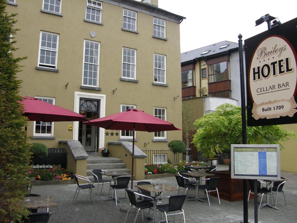 a hotel with tables and chairs in front of a building at Baileys Hotel Cashel in Cashel