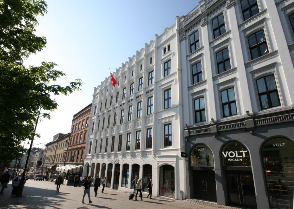 a white building with people walking in front of it at Comfort Hotel Karl Johan in Oslo