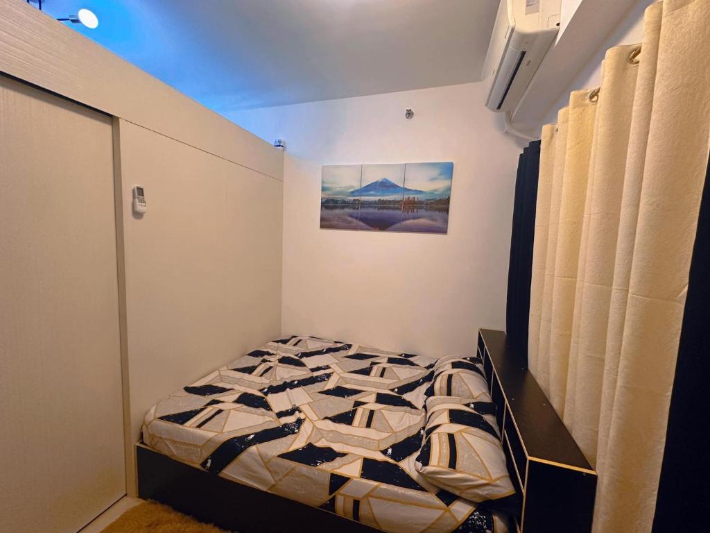 ein Schlafzimmer mit einem Bett in einem Zimmer in der Unterkunft SMDC coolsuites by Maryanne's staycation in Tagaytay