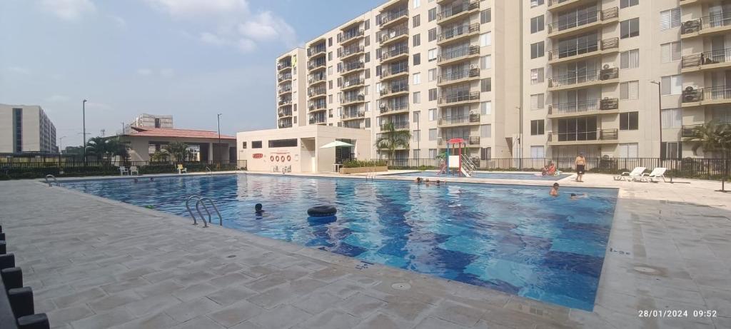 Apartamento vacacional, Ricaurte في ريكورت: مسبح كبير امام مبنى شقق كبيره