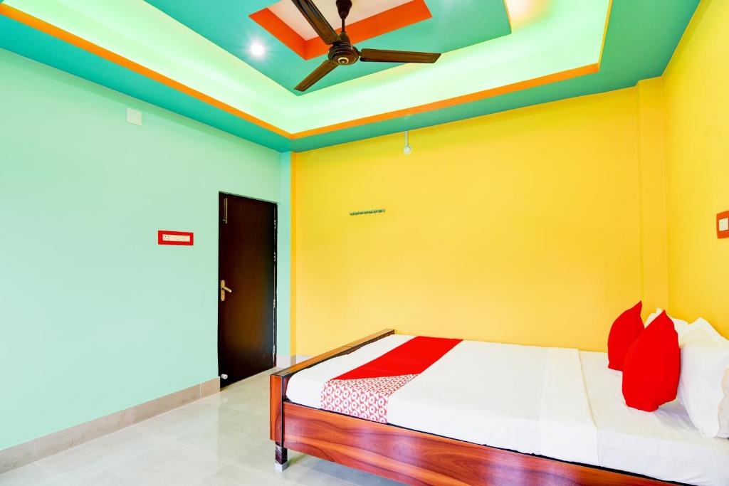 a bedroom with a bed and a ceiling fan at Dreams Inn in Kolkata