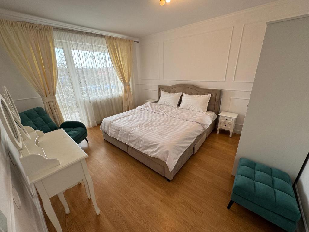 Private building - Apartment في بيستريتسا: غرفة نوم بسرير وطاولة وكراسي