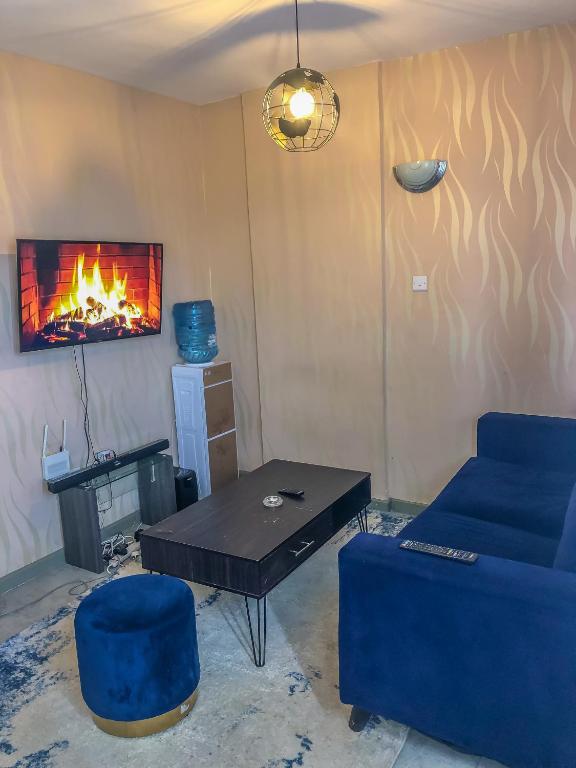 ein Wohnzimmer mit einem Sofa, einem Tisch und einem Kamin in der Unterkunft Harmony Condo in Nairobi