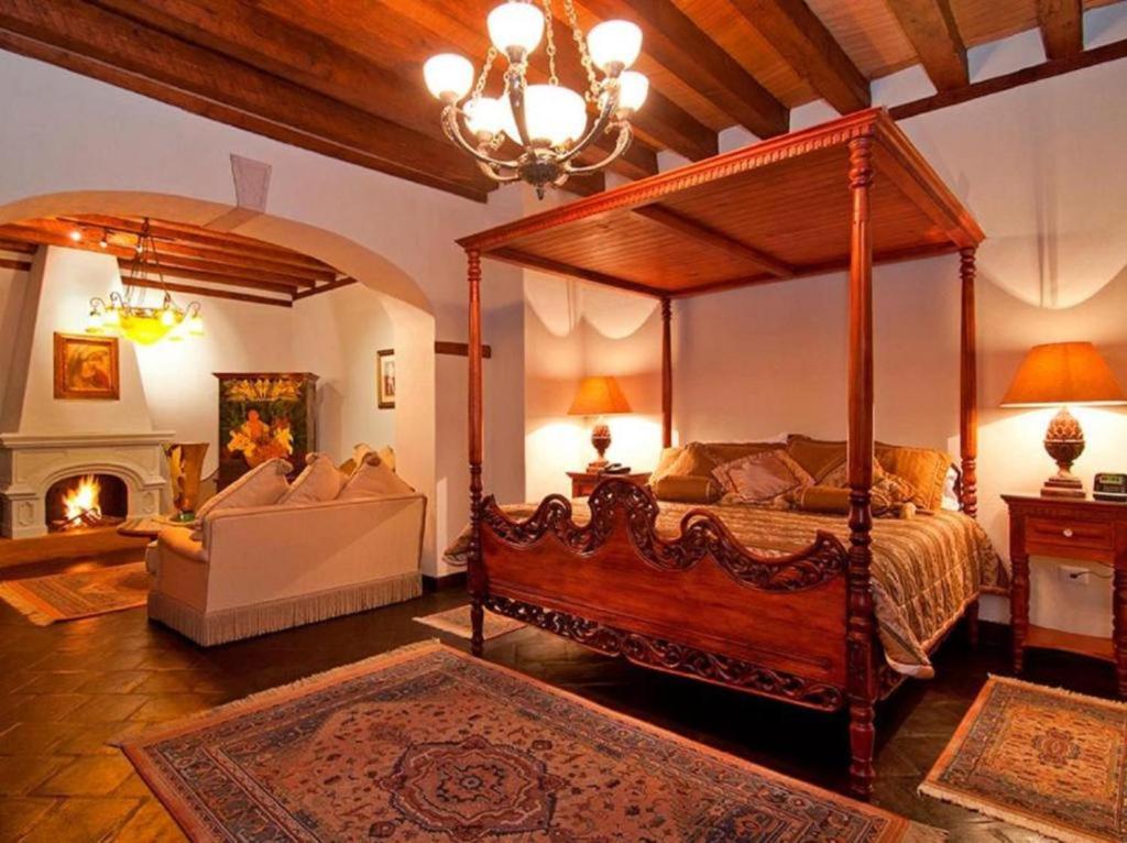 ein Schlafzimmer mit einem Himmelbett und einem Kamin in der Unterkunft Mansion de los Sueños in Pátzcuaro