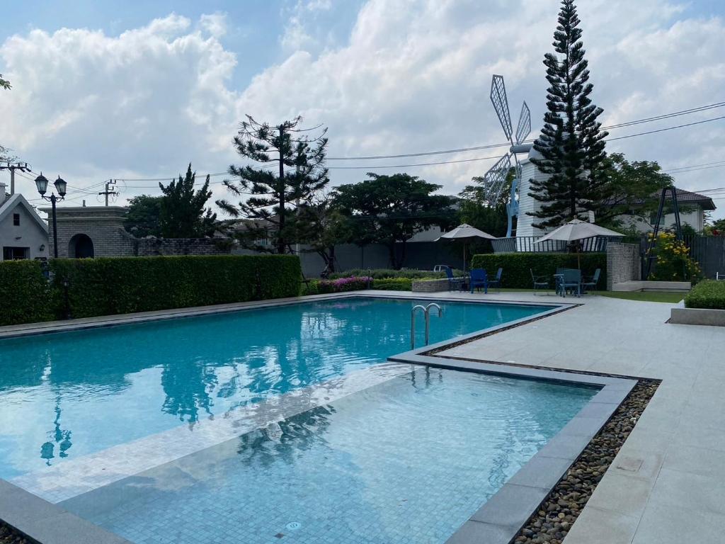 ein großer Pool mit blauem Wasser im Hof in der Unterkunft Indy 2 Bangna KM 7 Cozy Townhome near Ikea Mega Bangna 15m to Airport in Bang Kew Yai