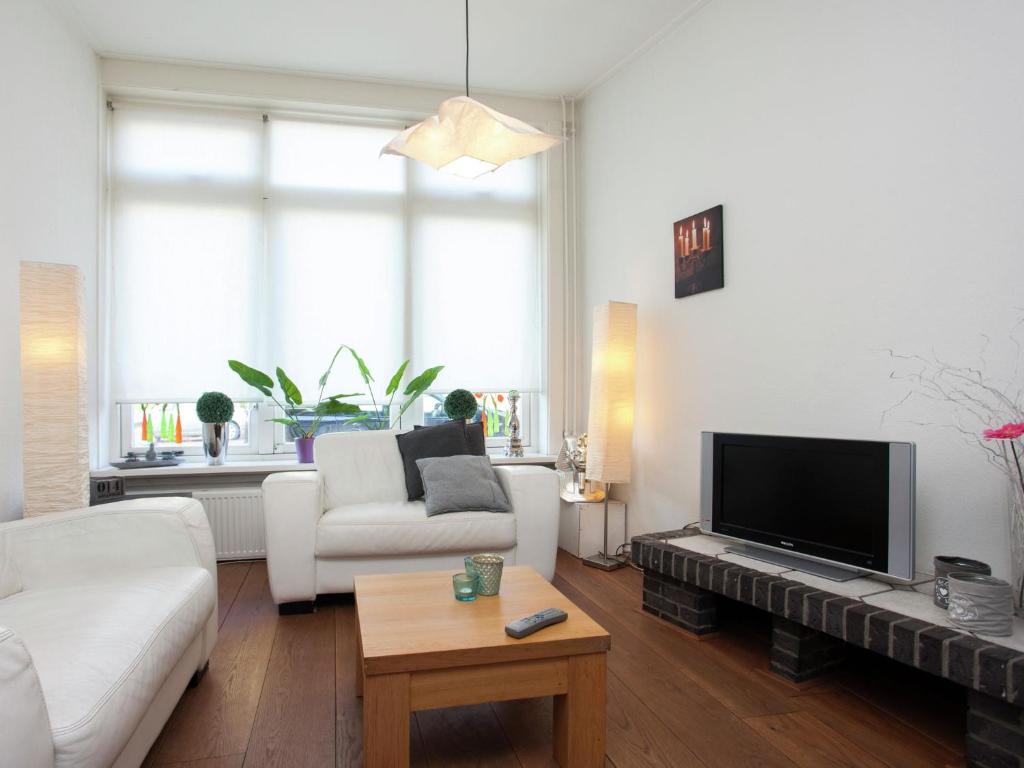 アルクマールにあるHoliday Home in Alkmaar by Canalのソファとテレビのあるリビングルーム