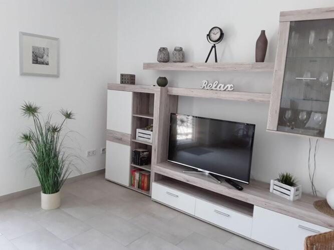 ein Wohnzimmer mit einem TV auf einem hölzernen Entertainment-Center in der Unterkunft Nice holiday apartment in Ostbevern in Ostbevern
