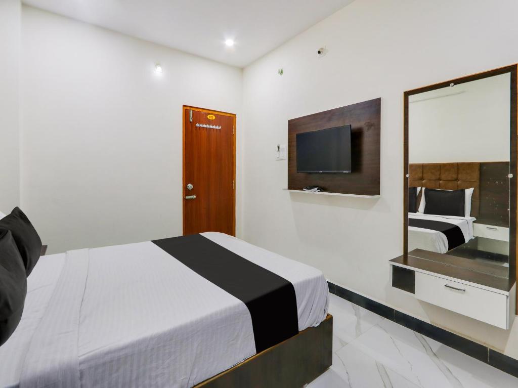 Super OYO Hotel Arjun Residency في Khammam: غرفه فندقيه سرير وتلفزيون
