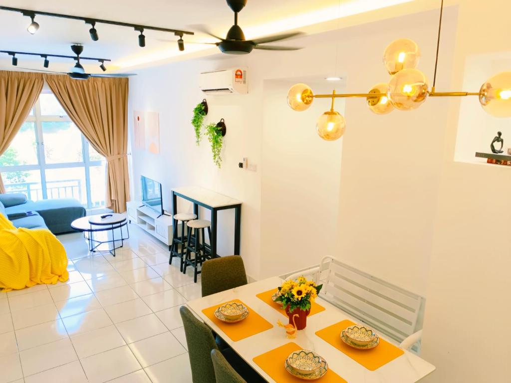 uma sala de estar com uma mesa com flores em Kulai Apartment 5BR11Pax near IOI, Aeon and Senai Airport em Kulai