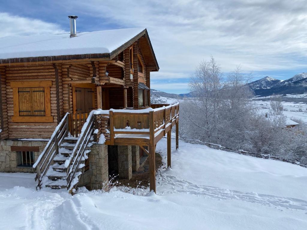 a log cabin in the snow with a staircase at Chalet en rondins avec magnifique vue in Font-Romeu-Odeillo-Via