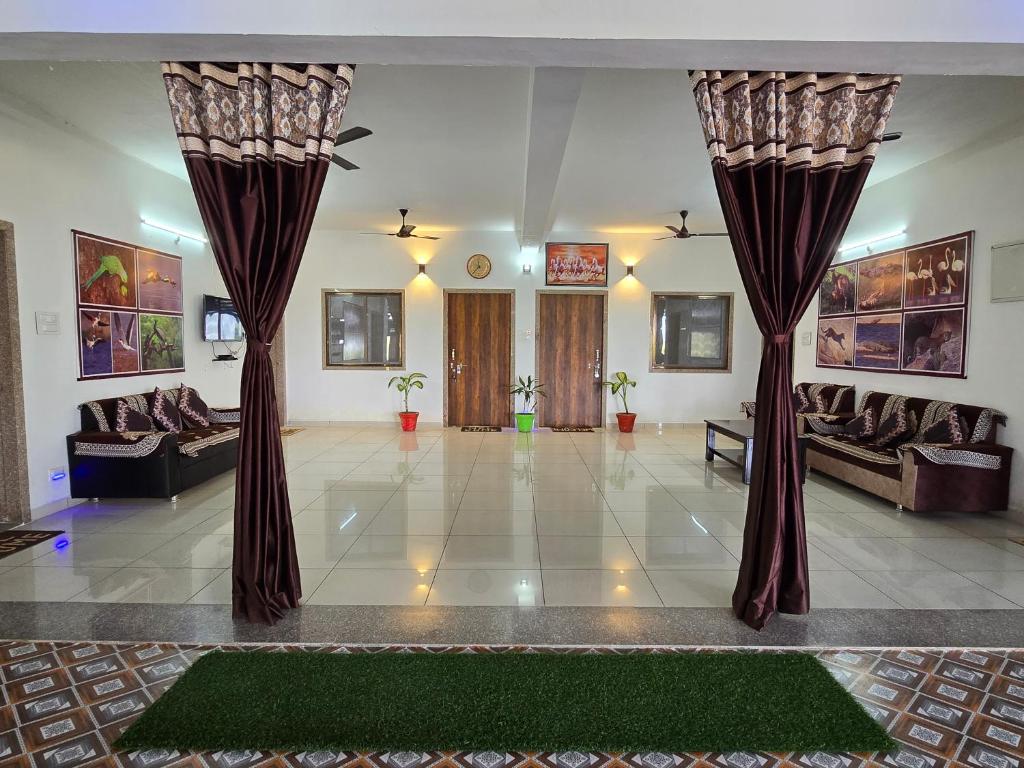 ein großes Wohnzimmer mit Vorhängen und einem Sofa in der Unterkunft Jawai Madan Lodge in Jawāi Bāndh