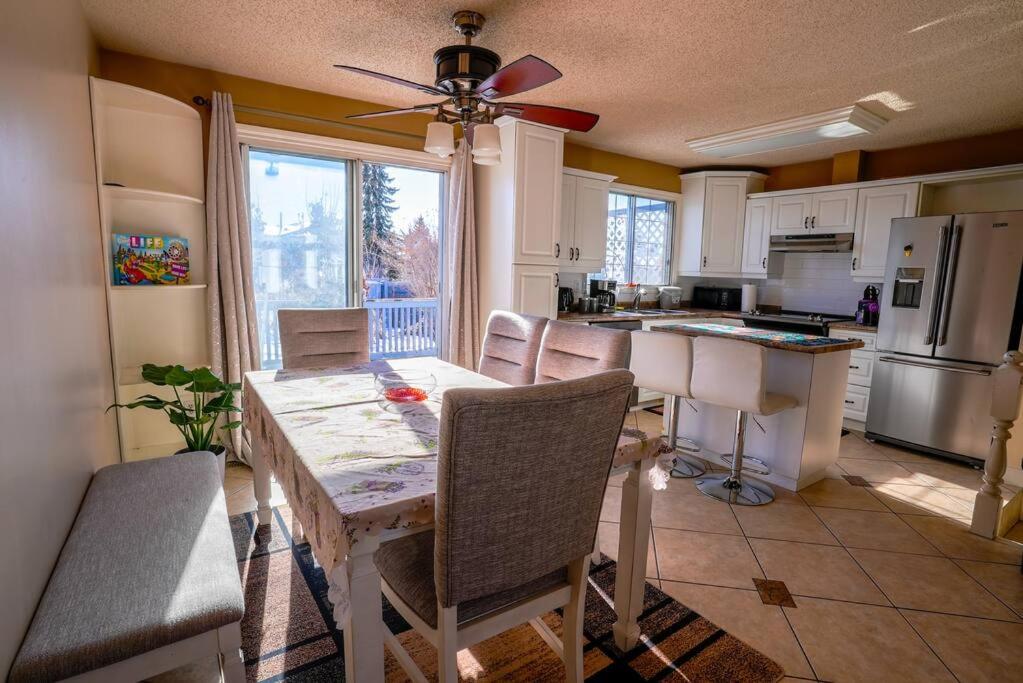 a kitchen with a table and chairs and a dining room at Beautiful 5 BDRM Home, Fenced Yard, WiFi, Fireplace, Free Parking, Transit, Town Centre - Sleeps 12 in Edmonton