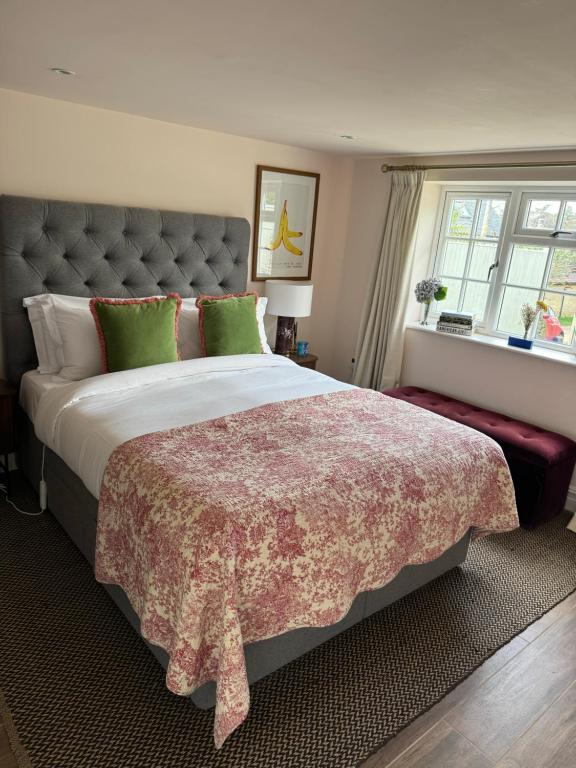 a bedroom with a large bed and a window at Cotswolds Cottage 5min from Soho Farmhouse in Chipping Norton