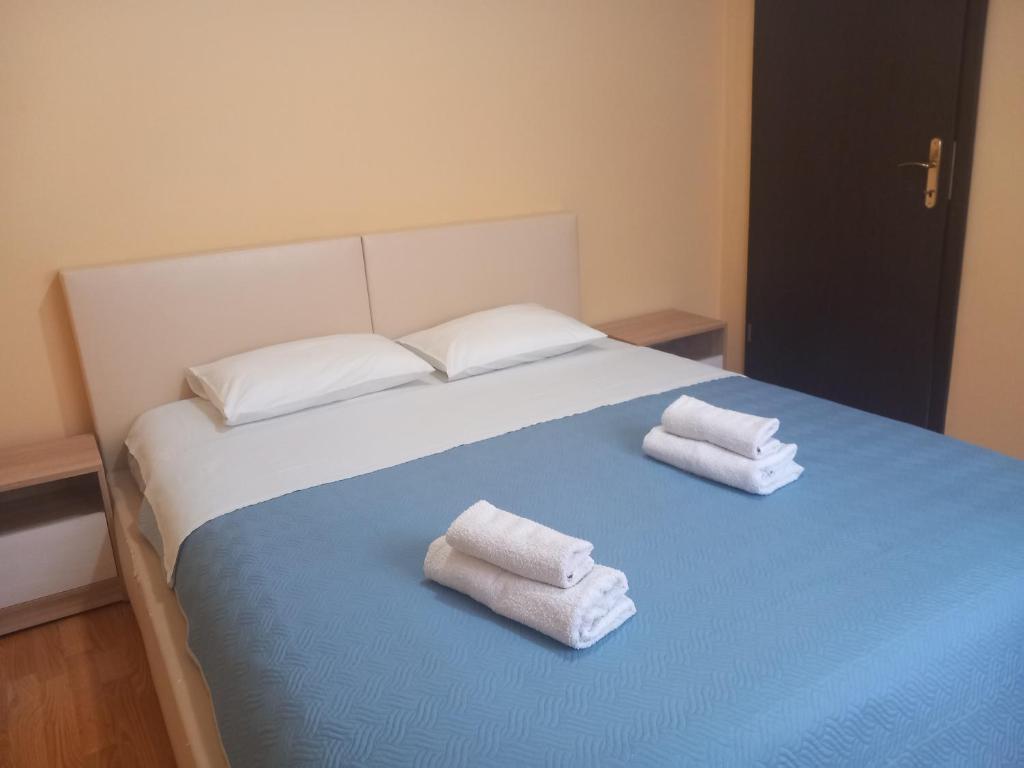 łóżko z dwoma ręcznikami na górze w obiekcie Apartment Filipovic w mieście Podgorica