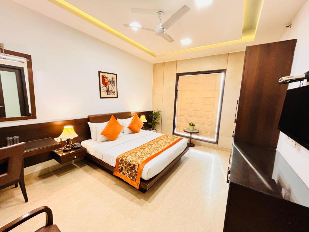1 dormitorio con 1 cama con almohadas de color naranja en Hotel Lavish Inn Rajouri Garden Couple Friendly, New Delhi en Nueva Delhi