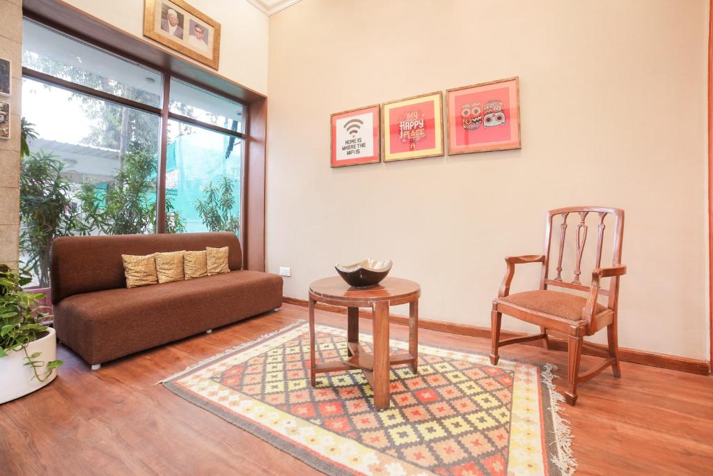 a living room with a couch and a chair at Super Townhouse 1267 Dayal Lodge - A Boutique Hotel in Agra