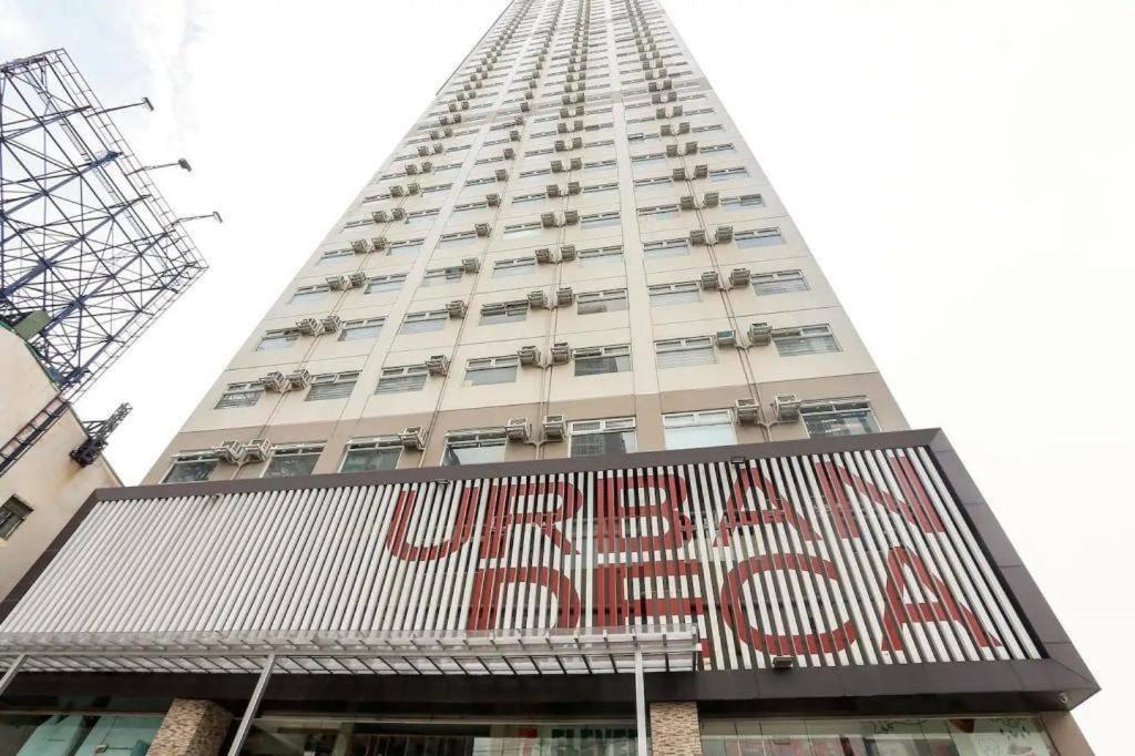 a tall building with a sign in front of it at Urban Deca Tower EDSA in Manila