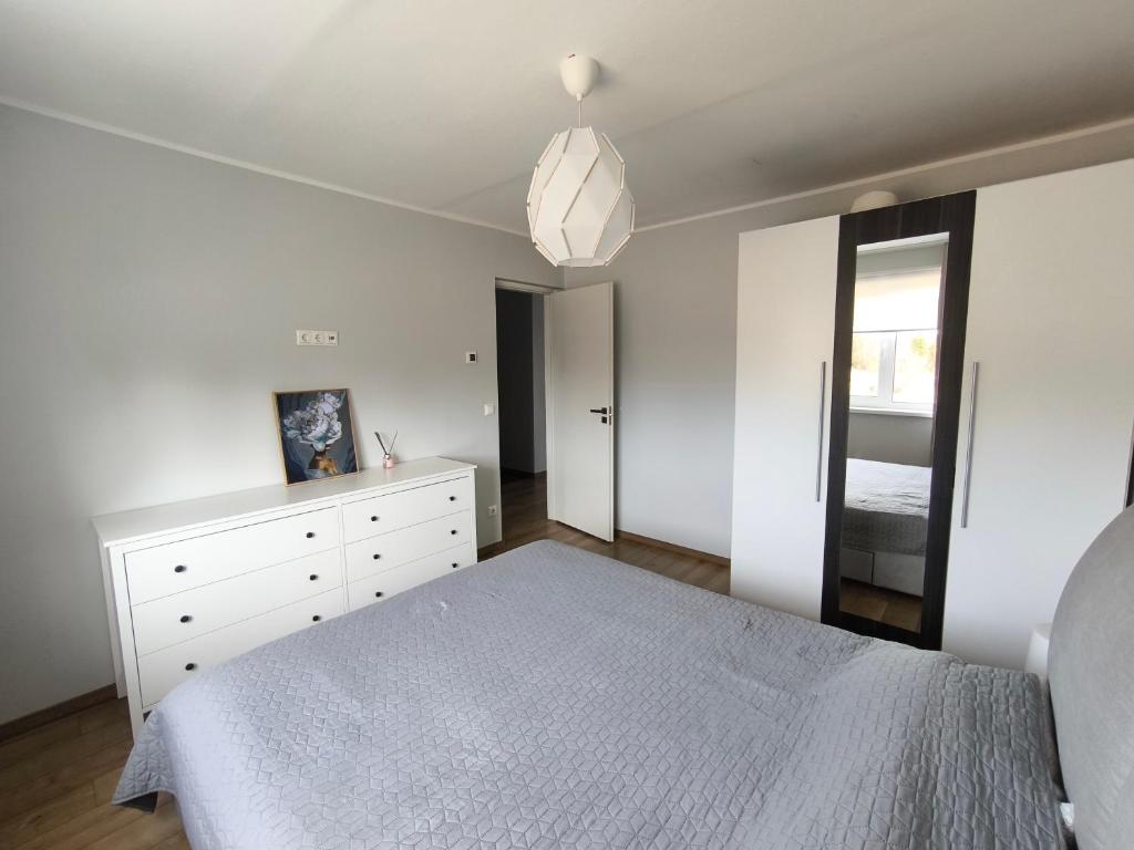 - une chambre blanche avec un lit et un miroir dans l'établissement Särevere apartment, à Särevere Asundus