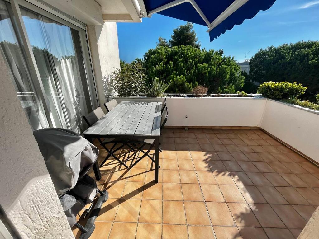 un patio avec une table et des chaises sur un balcon dans l'établissement Appartement T2 avec parking, climatisé à 7 min de la plage - La Grande Motte Centre Ville - FR-1-716-36, à La Grande Motte