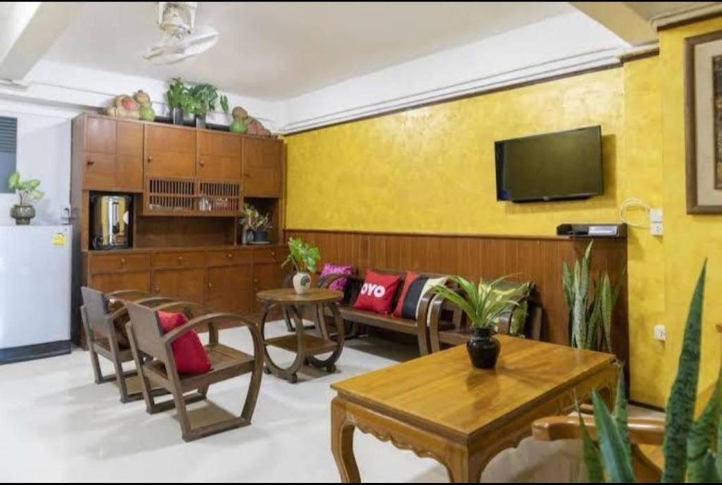 een woonkamer met een bank en een tafel bij Mona House Phuket in Ban Na Bon