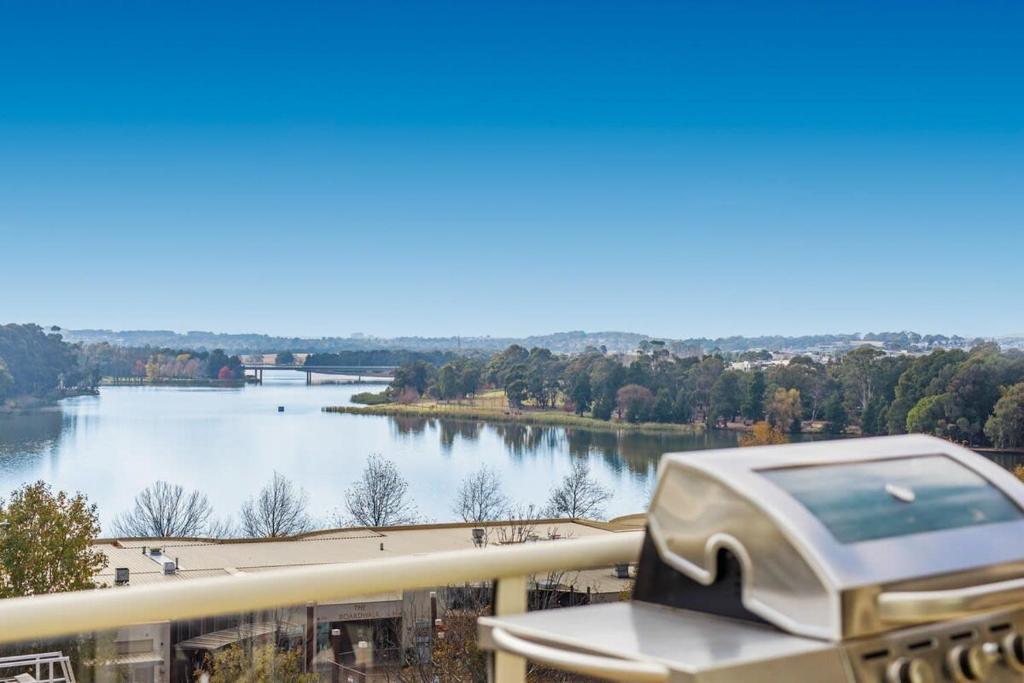 a device on a balcony with a view of a river at 2-Bed Unit with Balcony BBQ & Stunning Lake Views in Belconnen