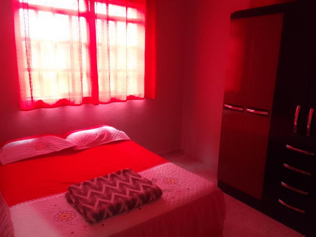 a red bedroom with a bed with a red light at Casa espaçosa no Bethânia in Ipatinga