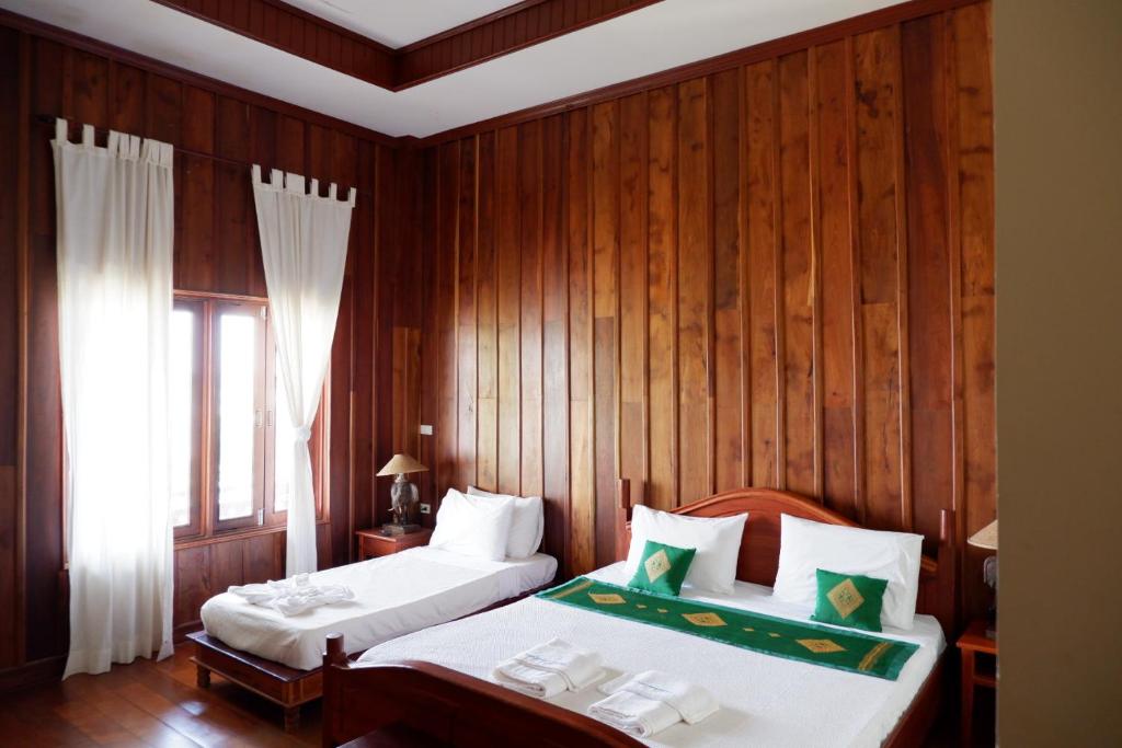Postel nebo postele na pokoji v ubytování Kongmany Prestige Hotel